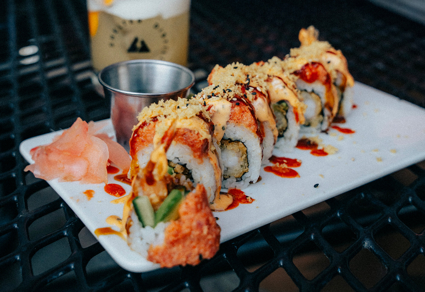 California roll tempura-fried and topped with spicy tuna mix. Finished with eel sauce, sriracha aioli, sesame seeds, and togarashi at Shelter Distilling in the Village at Mammoth Lakes, CA